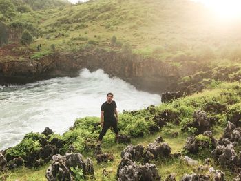 Man standing on rock by sea