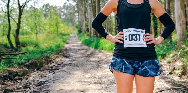 Midsection of woman running on road