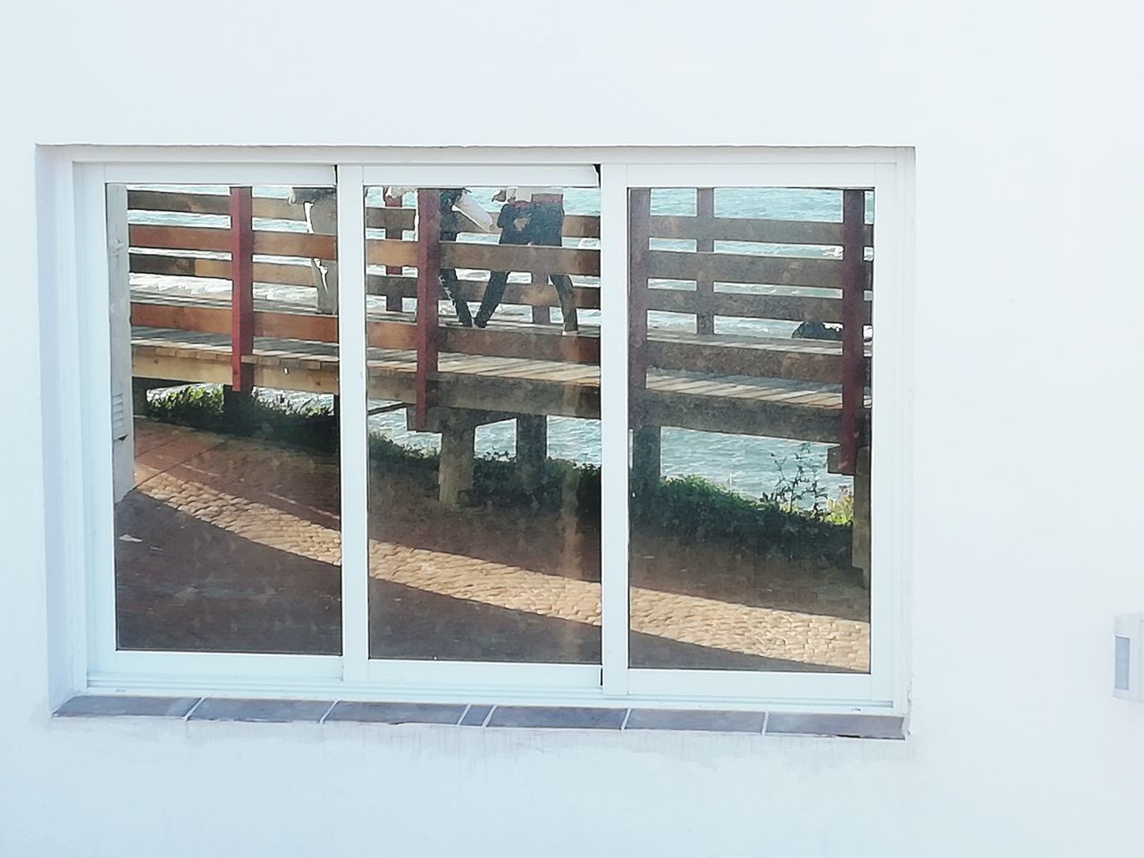 REFLECTION OF WOMAN ON WINDOW OF BUILDING