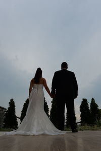 Rear view of couple holding hands