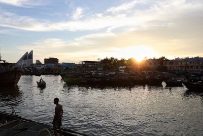 View of city at waterfront during sunset