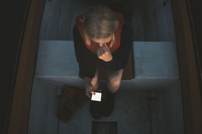 High angle view of woman using mobile phone while sitting in boat