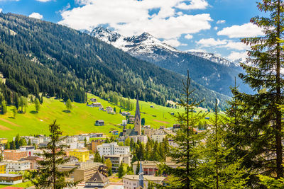 Scenic view of townscape and mountains against sky