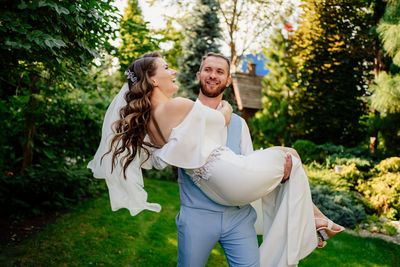 Young couple kissing against plants