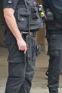 Midsection of men standing in front of people