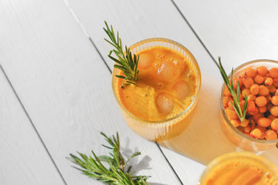 Raw sea buckthorn juice in glasses. with rosemary. antioxidant drinkfor immunity boost in spring. 