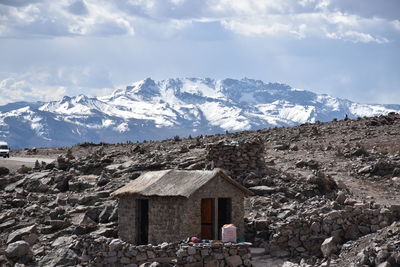 Houses on snowcapped mountain against sky