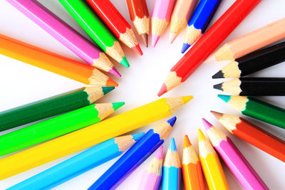 High angle view of multi colored pencils against white background