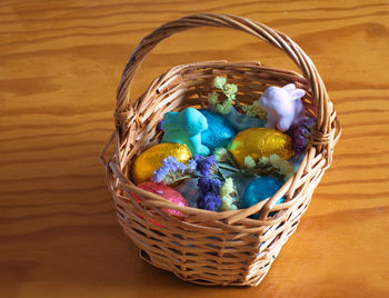 High angle view of multi colored eggs in basket on table