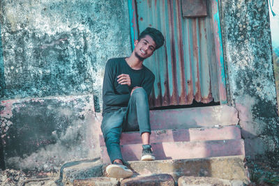 Portrait of a smiling young man against wall