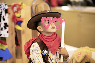 Boy in cowboy costume holding prop