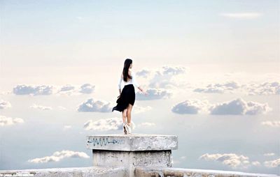 Rear view of woman standing against sky