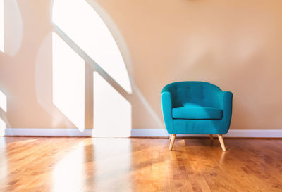 Empty chair against blue wall at home