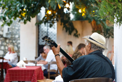 Rear view of a man playing music