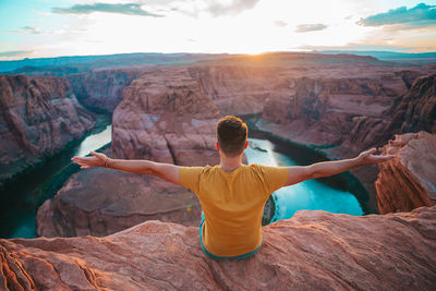 Rear view of man standing on rock formations