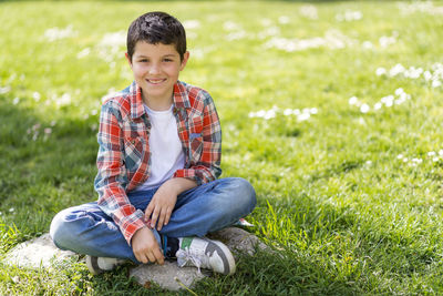 Portrait of smiling boy sitting at park