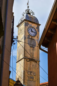 Low angle view of clock tower amidst buildings against sky