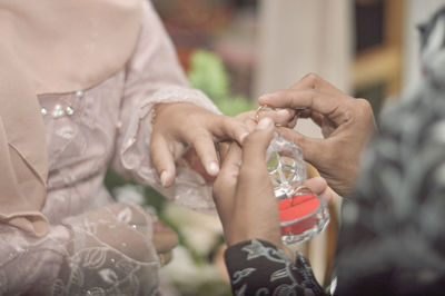 Midsection of couple holding hands