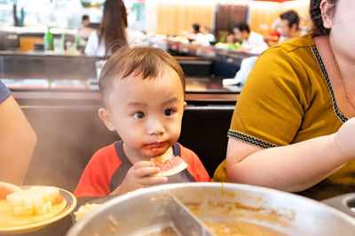 Portrait of cute boy eating food at restaurant