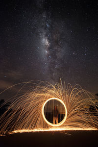 Low angle view of illuminated lighting equipment against sky at night