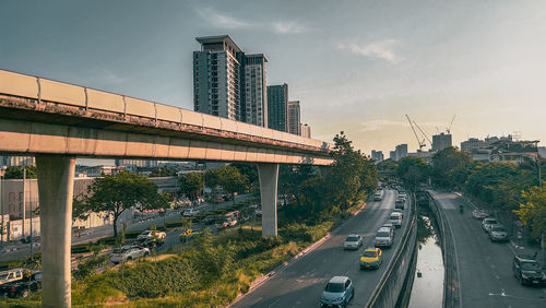 Vehicles on road against sky in city