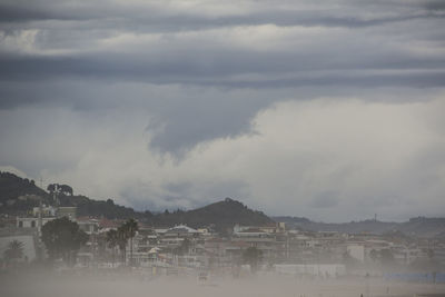Scenic view of town by mountains against sky