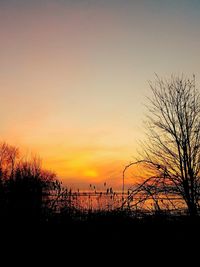 Silhouette landscape against dramatic sky during sunset