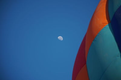 Low angle view of half moon against blue sky