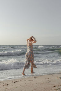 Full length of boy on beach against clear sky