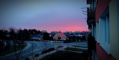 High angle view of road by buildings against sky at sunset