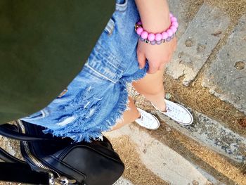 Low section of woman standing on footpath