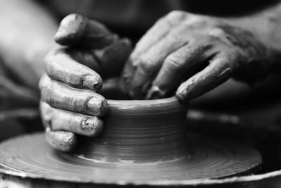 Cropped hand making pottery at workshop