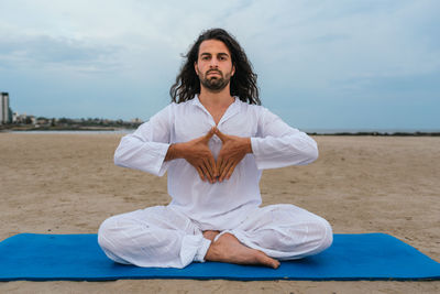 Full length of man sitting outdoors