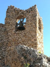 Low angle view of stone wall against sky