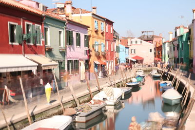 Boats in canal amidst buildings in town