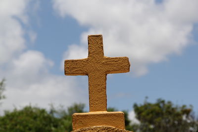 Cross in cemetery against sky