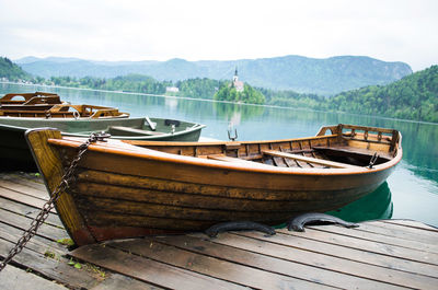 Boats moored by pier on lake