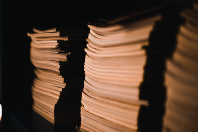 Close-up of stacked books against black background