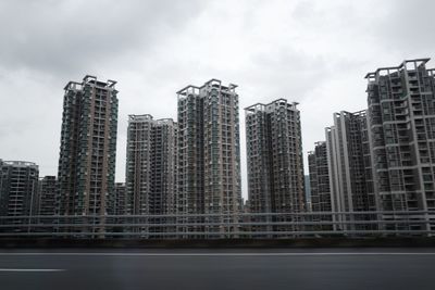 Modern buildings in city against cloudy sky