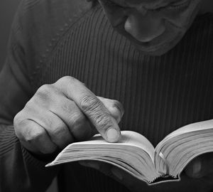 Midsection of man holding book