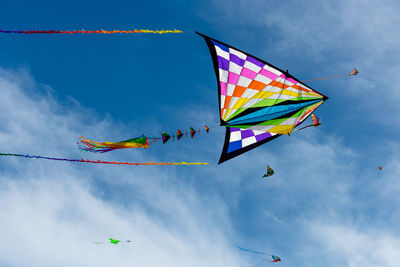 Low angle view of colorful kites flying in sky