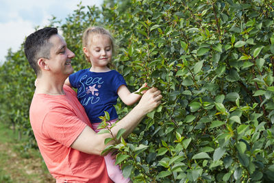 Father and son standing by plants