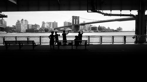 People against brooklyn bridge on east river in manhattan