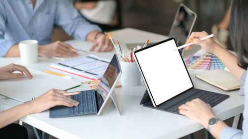 Midsection of woman using mobile phone at table