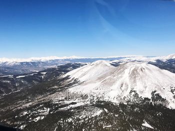 Scenic view of snowcapped mountains against clear blue sky