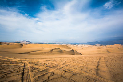 Tire tracks on sand dunes in desert