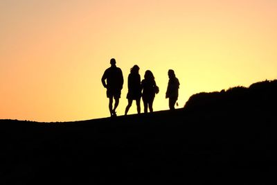Silhouette people against clear sky during sunset