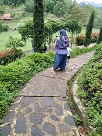 Rear view of woman walking on footpath