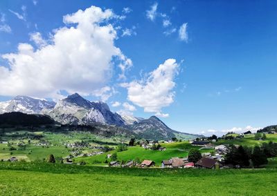 Panoramic view of green landscape and mountains against sky