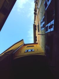 Low angle view of yellow building against sky